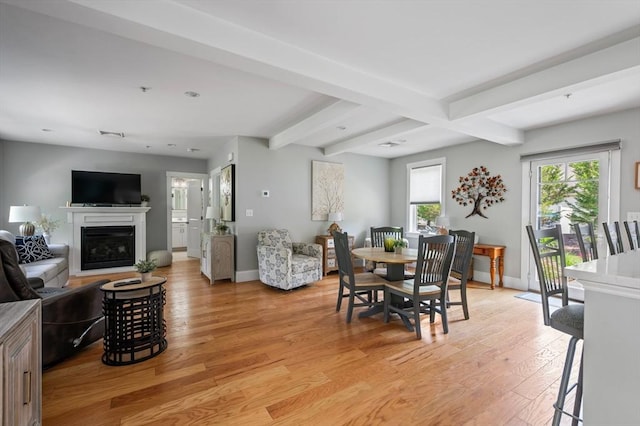 599 Washington St Unit 1, Pembroke, MA 02359 - dining room with light wood finished floors, beam ceiling, and a glass covered fireplace