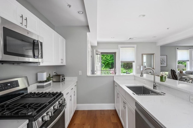 599 Washington St Unit 1, Pembroke, MA 02359 - kitchen featuring stainless steel appliances, wood finished floors, light stone counters, white cabinetry, and recessed lighting