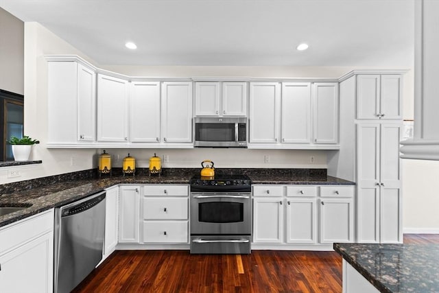 kitchen with dark stone countertops, recessed lighting, white cabinets, dark wood finished floors, and appliances with stainless steel finishes