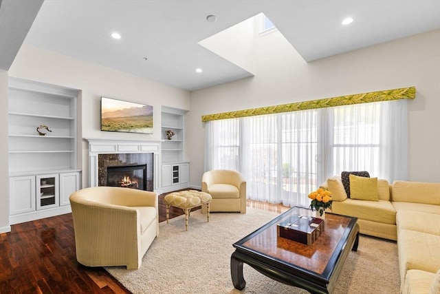 living room with recessed lighting, built in features, dark wood-style floors, and a premium fireplace