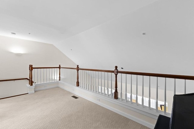 additional living space with baseboards, visible vents, light carpet, and vaulted ceiling