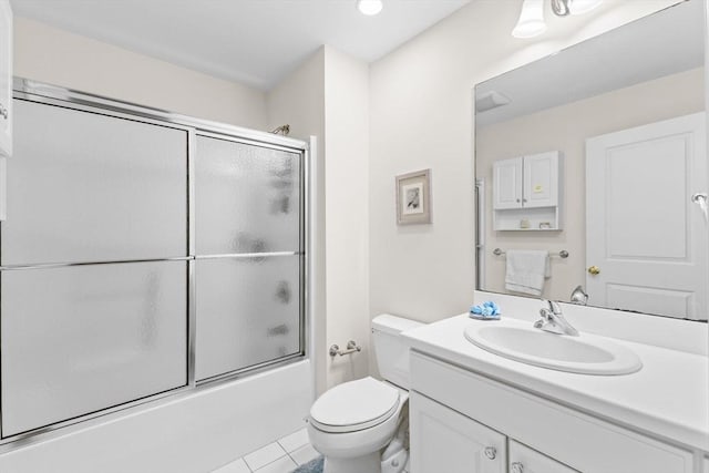 bathroom featuring vanity, tile patterned flooring, combined bath / shower with glass door, and toilet