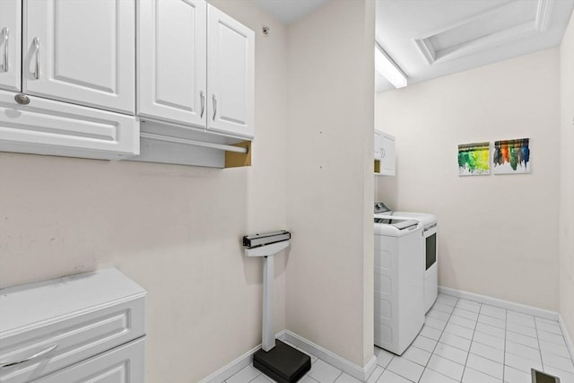washroom with baseboards, attic access, cabinet space, and washing machine and clothes dryer