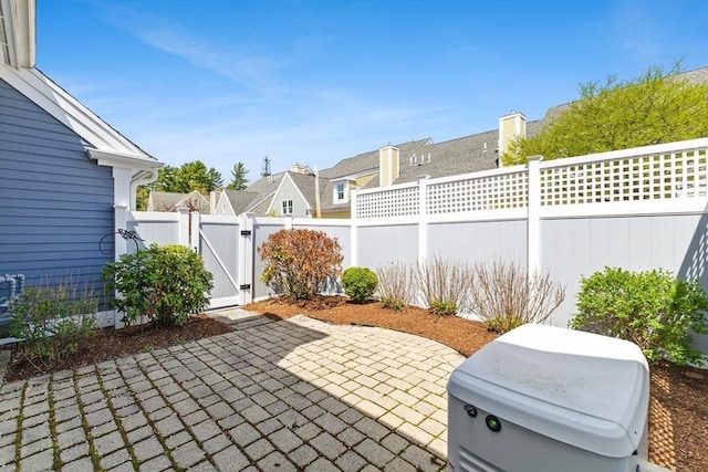 view of patio / terrace featuring a gate, a fenced backyard, and a residential view