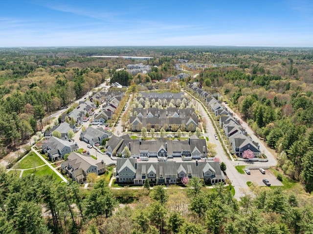 drone / aerial view featuring a residential view and a wooded view