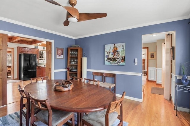 dining area with ornamental molding, a ceiling fan, and light wood-style flooring