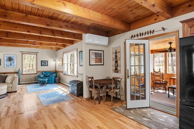 interior space with an AC wall unit, a baseboard heating unit, light wood finished floors, and beam ceiling