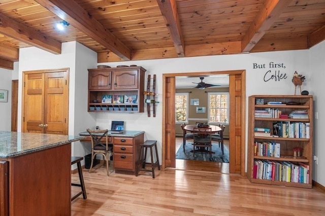 home office with a ceiling fan, light wood-style flooring, wooden ceiling, and beamed ceiling