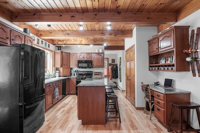 kitchen with light wood finished floors, black appliances, a breakfast bar, and wooden ceiling
