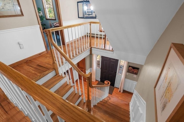 stairs featuring a wainscoted wall, a baseboard radiator, and wood finished floors