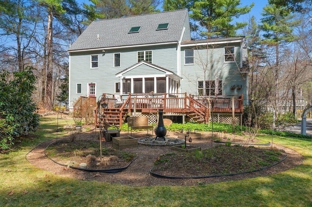 rear view of house with a deck, stairs, a sunroom, and roof with shingles