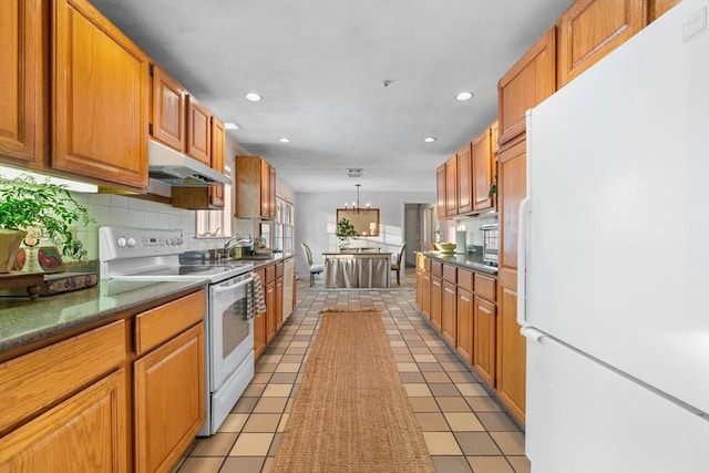 kitchen featuring decorative backsplash, hanging light fixtures, light tile patterned floors, a notable chandelier, and white appliances