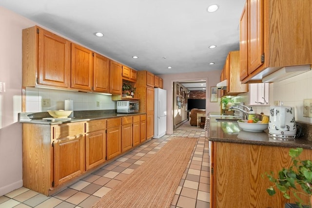 kitchen featuring tasteful backsplash, sink, and white fridge