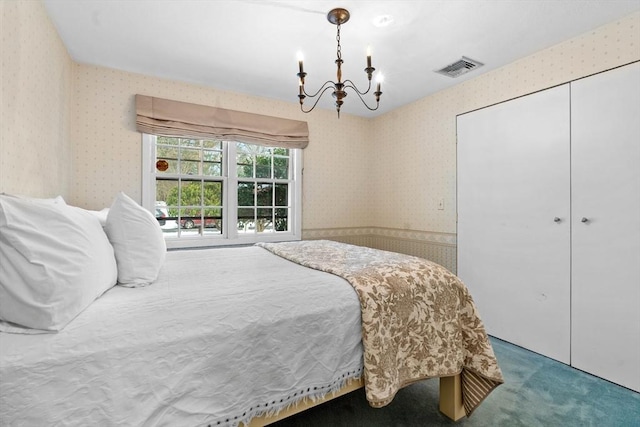 bedroom with an inviting chandelier, carpet flooring, and a closet