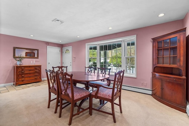 carpeted dining area with a baseboard heating unit