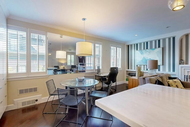 dining space with ornamental molding and dark hardwood / wood-style floors