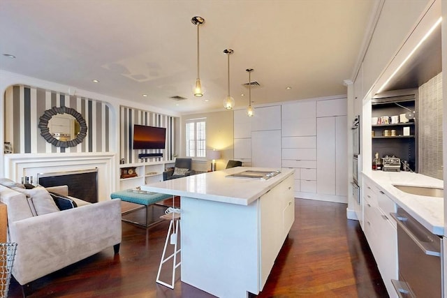 kitchen with white cabinetry, dark hardwood / wood-style floors, a center island, and hanging light fixtures