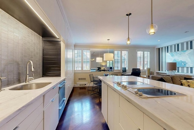 kitchen featuring dark hardwood / wood-style flooring, sink, pendant lighting, and light stone counters