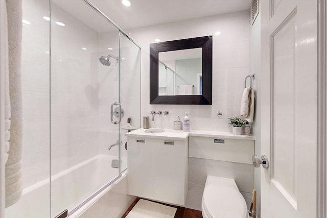 full bathroom featuring bath / shower combo with glass door, vanity, and toilet