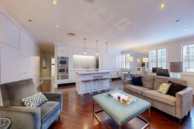 living room featuring crown molding, dark hardwood / wood-style floors, and sink