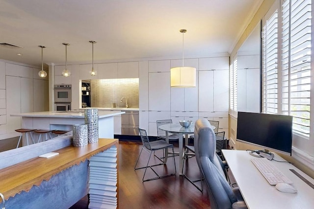 dining room featuring sink and dark wood-type flooring