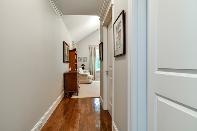 hallway featuring dark hardwood / wood-style flooring and vaulted ceiling