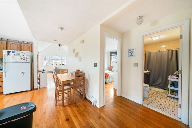 dining space featuring a baseboard radiator and light hardwood / wood-style floors