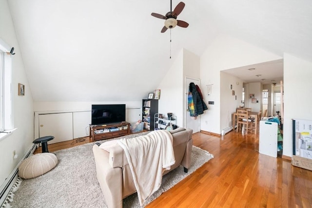 living room with baseboard heating, lofted ceiling, wood-type flooring, and ceiling fan