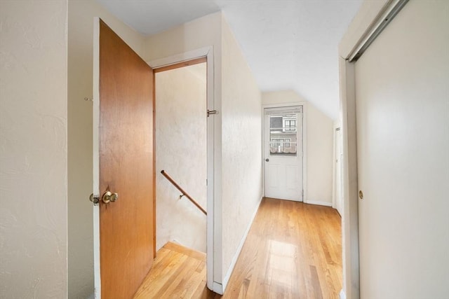 corridor featuring vaulted ceiling and light hardwood / wood-style floors