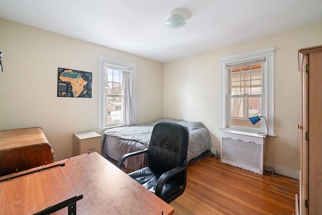 bedroom featuring radiator and light wood-type flooring