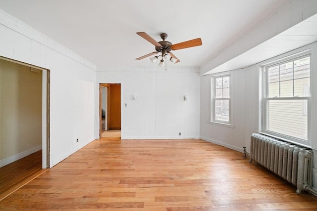 unfurnished room with radiator, ceiling fan, and light wood-type flooring