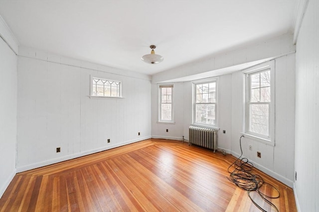 spare room with hardwood / wood-style flooring and radiator heating unit