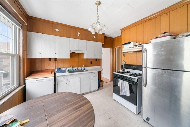 kitchen featuring sink, gas range, stainless steel refrigerator, dishwasher, and pendant lighting