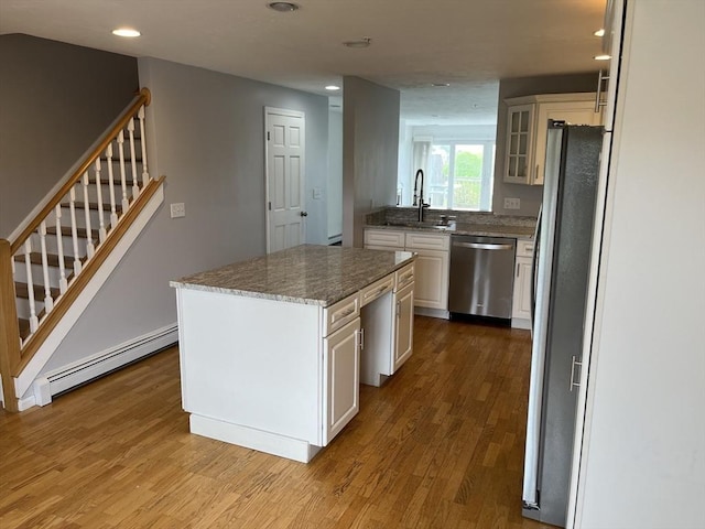 24 Highland Ter Unit 2415, Plymouth, MA 02360 - kitchen with appliances with stainless steel finishes, a baseboard radiator, a sink, wood finished floors, and recessed lighting
