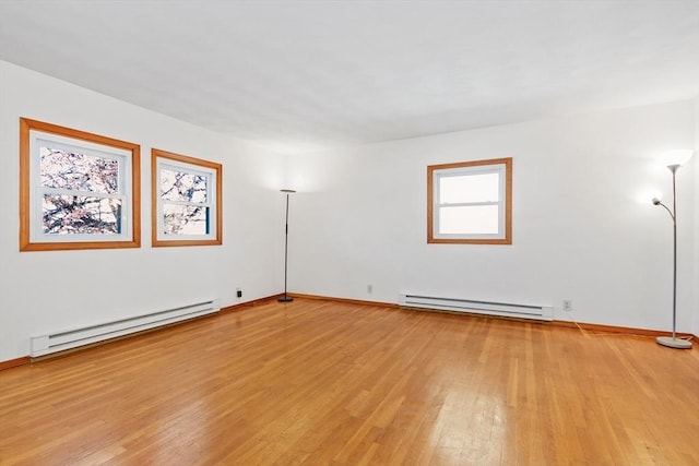 spare room featuring light wood-type flooring and baseboard heating