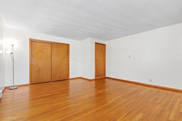 unfurnished bedroom with a closet and light wood-type flooring