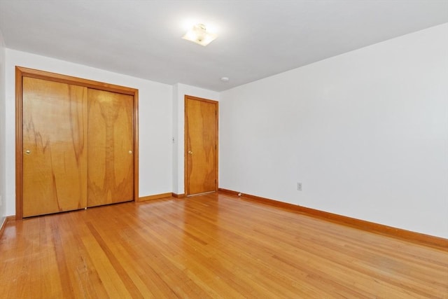 unfurnished bedroom with a closet and light wood-type flooring