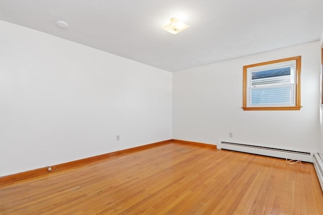 empty room with light hardwood / wood-style floors and a baseboard radiator