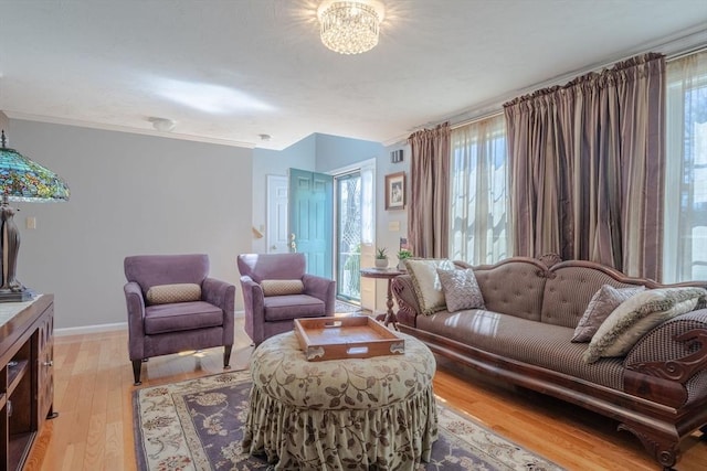 living area featuring baseboards, light wood-style floors, and plenty of natural light