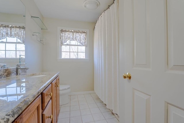 full bathroom with tile patterned flooring, toilet, a healthy amount of sunlight, and vanity