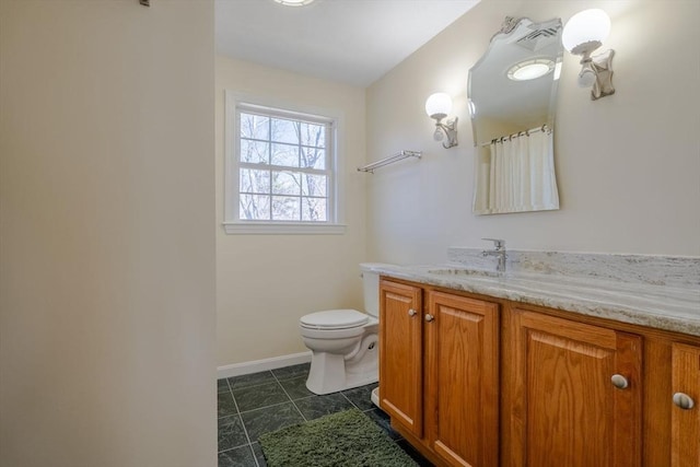 full bathroom featuring toilet, vanity, tile patterned floors, and baseboards