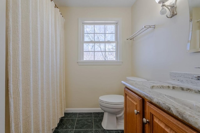 bathroom featuring toilet, vanity, tile patterned floors, and baseboards