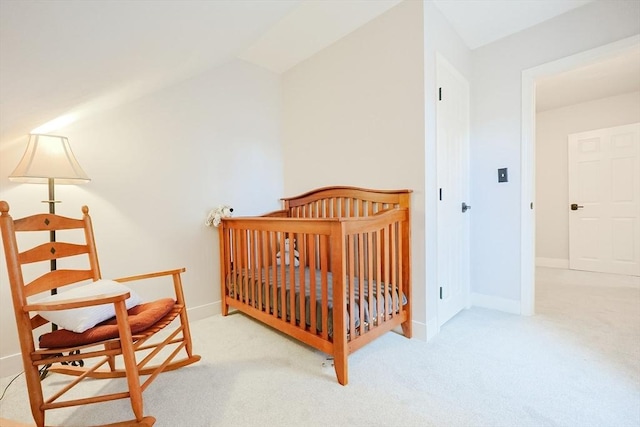 bedroom featuring a crib and light carpet