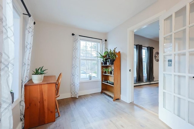 doorway to outside with a baseboard radiator and light hardwood / wood-style floors