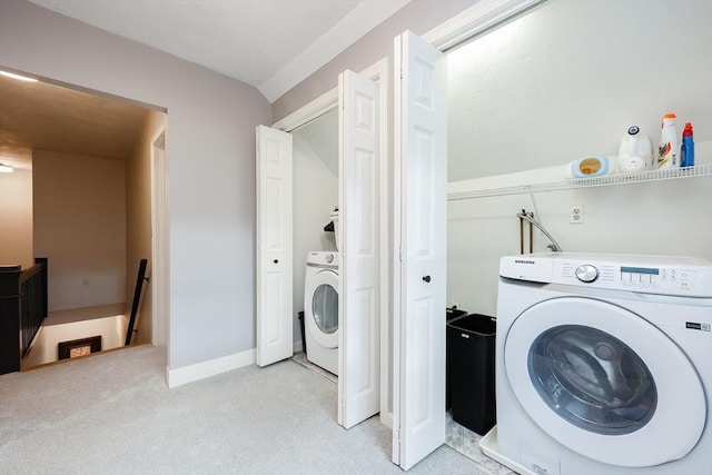 clothes washing area with washer / clothes dryer and light carpet