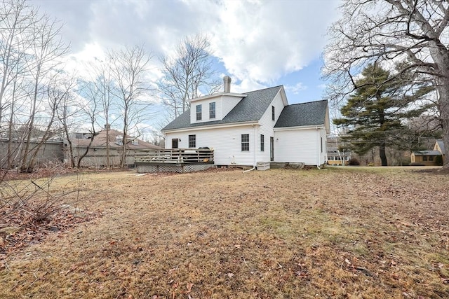 back of house featuring a deck and a lawn