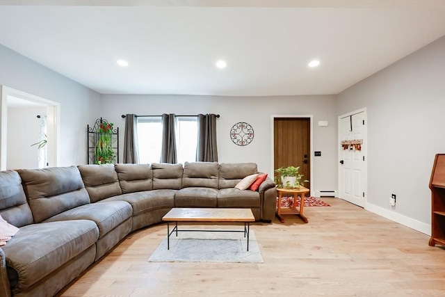 living room with baseboard heating and light hardwood / wood-style flooring