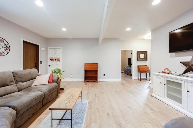 living room featuring beam ceiling and light hardwood / wood-style floors