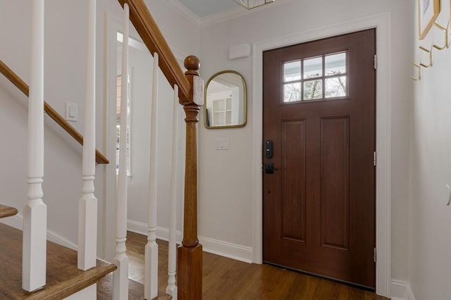 entryway with ornamental molding and dark hardwood / wood-style floors