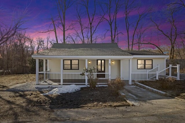 view of front facade featuring covered porch and a shingled roof